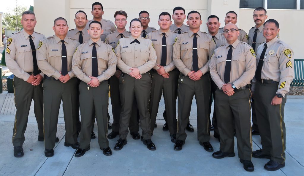 Two sergeants with correctional officer cadets at the academy.
