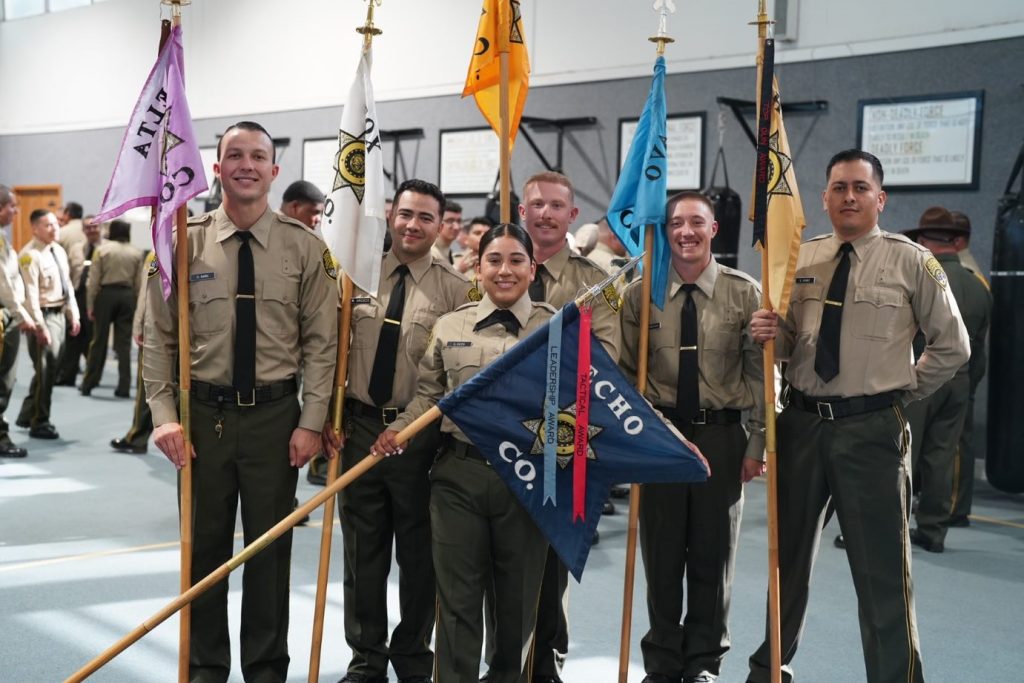 Cadets wait to carry in flag-style banners representing their various companies at the correctional officer academy. 