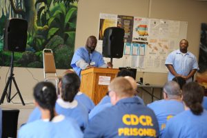 man standing in front of ISUDT group giving graduation speech at Wasco State Prison-Reception Center.