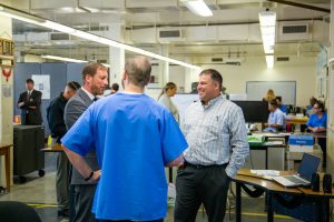 A judge and prison warden speak with a Peer Literacy Mentor Program tutor.