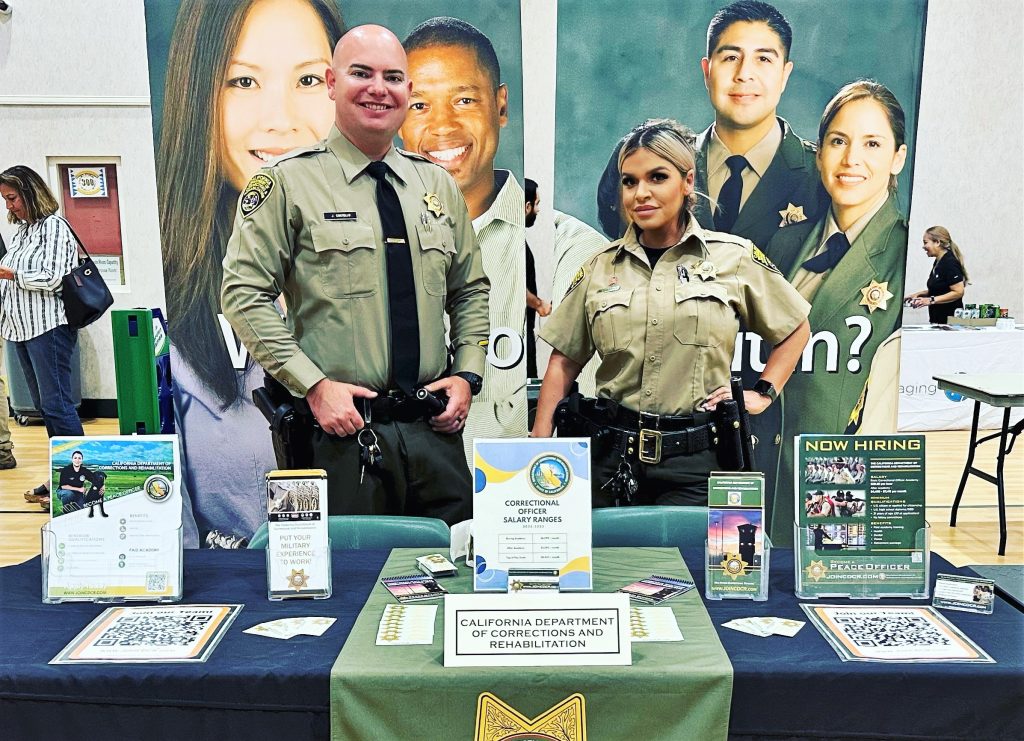 Correctional officers at a CDCR recruitment booth.