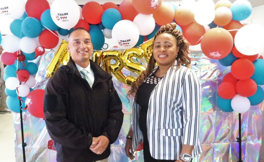 Prison warden and director of nursing standing in front of balloons.