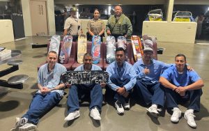 Four incarcerated artists with skateboards and three Avenal State Prison staff.