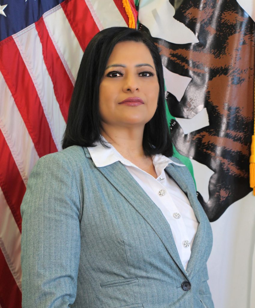 Sonia Bahro in front of a flag.