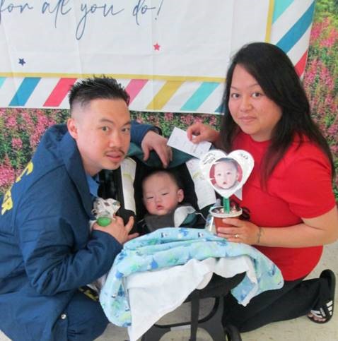 Staff stuffed flower pots with candy and a photo of the family's child for Mother's Day visiting at California Medical Facility. A mom, her baby and incarcerated loved one pose for a photo.