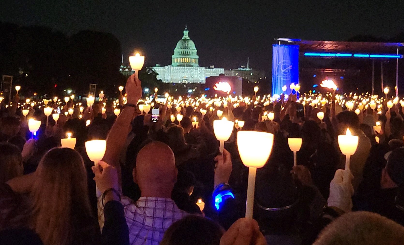 People hold candles in front of the capitol building in Washington D.C.