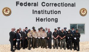 group of people standing in front of FCI Herlong sign