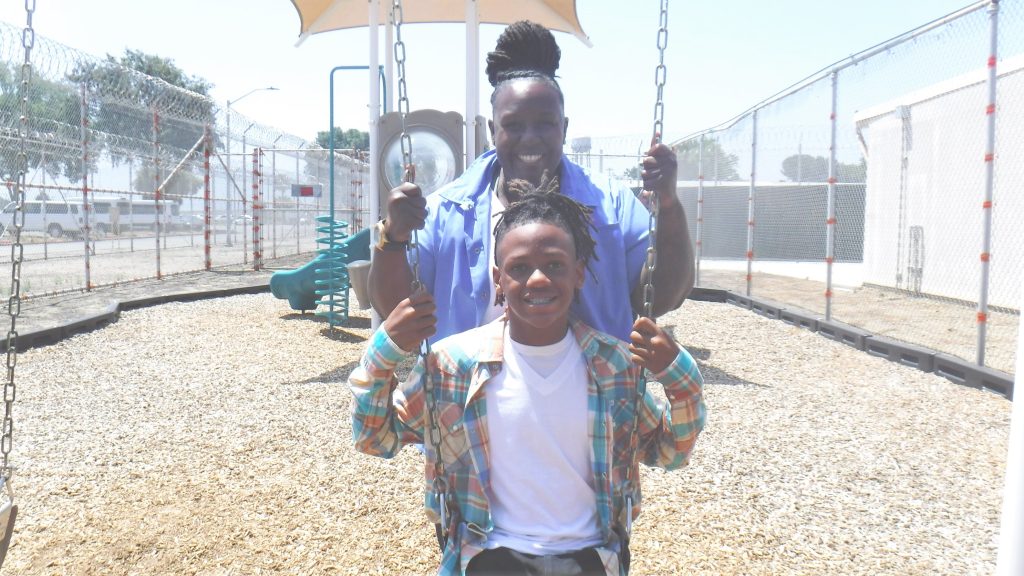 An incarcerated mom and her child enjoy the swing at California Institution for Women.