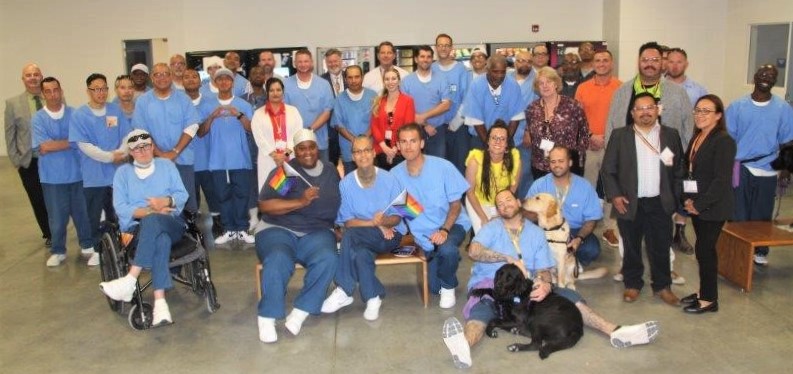Incarcerated people and prison staff pose for a group photo.