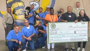 ASP Paws estates program holding a large check