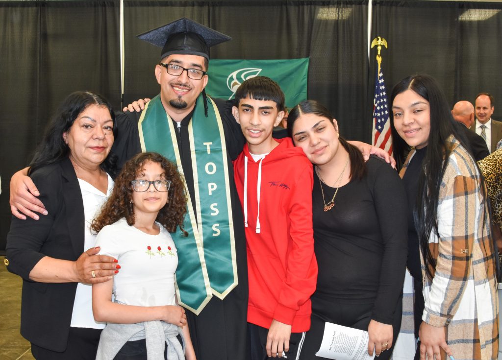 An incarcerated person and his family at a graduation ceremony. 
