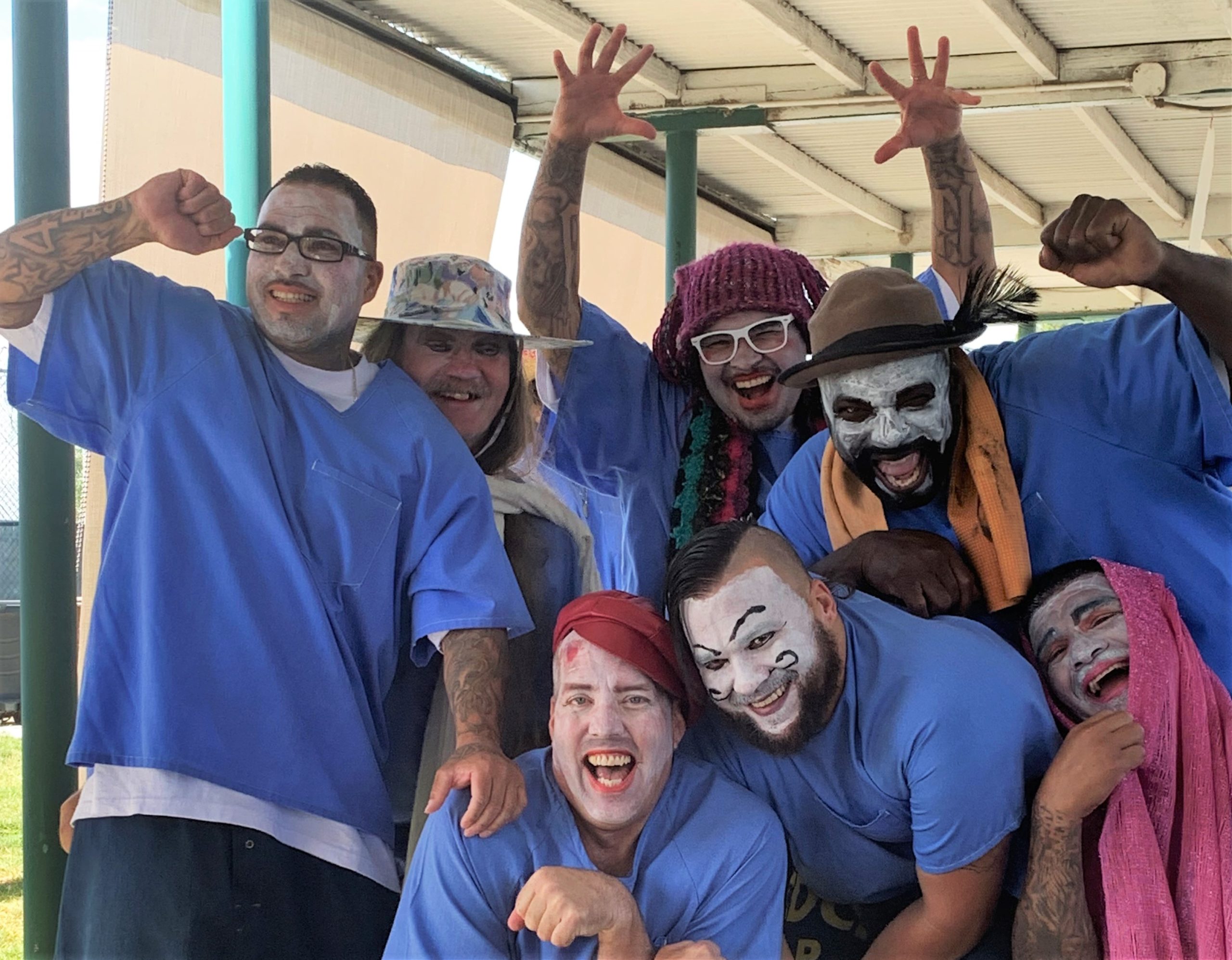 The Actors' Gang Prison Project at CIM with incarcerated actors wearing makeup and displaying emotions.