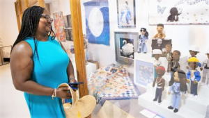 Adwoa Cooper stands beside her crocheted hip-hop dolls on display at the California State Fair.