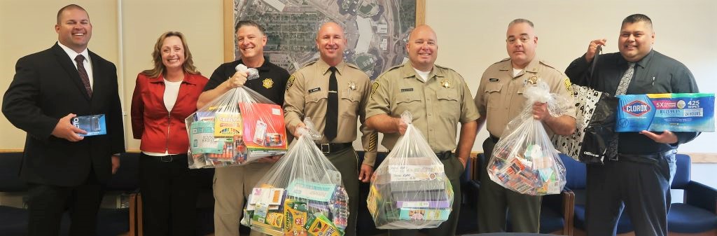 SAC staff hold back to school supplies gathered by prison employees.