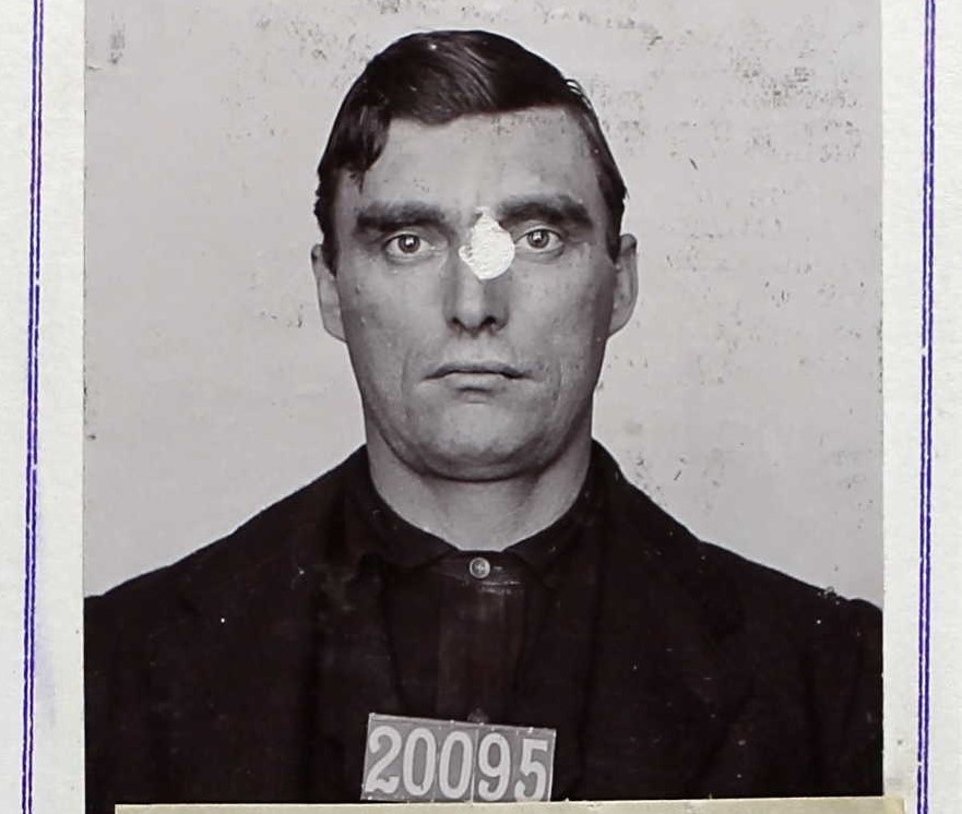 San Quentin mugshot of John Aborn, or Abron, 20095. He's without his mustache and wearing dark clothing. The 1903 photo is somewhat damaged by age.
