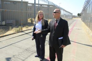 Featured image for A Day in the Life series showing two associate warden walking a path outside a secure fence at California State Prison, Solano.