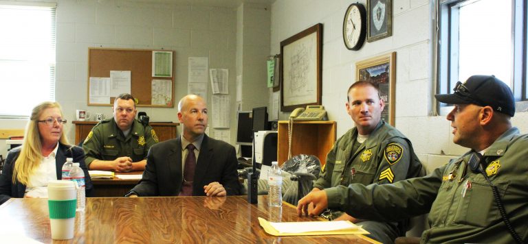 Associate wardens meet with prison staff at a conference table.