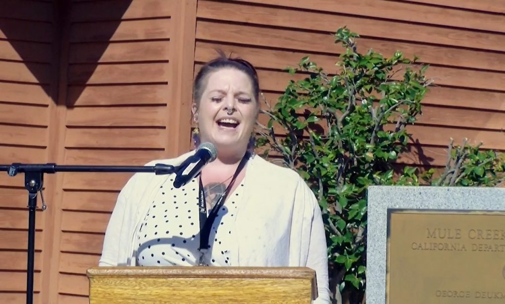 Woman sings at Mule Creek State Prison during a 9/11 ceremony.
