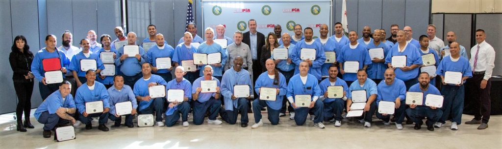 Fifty students at CALPIA hold certificates at the second of two graduations held in one week at Folsom State Prison (FSP).