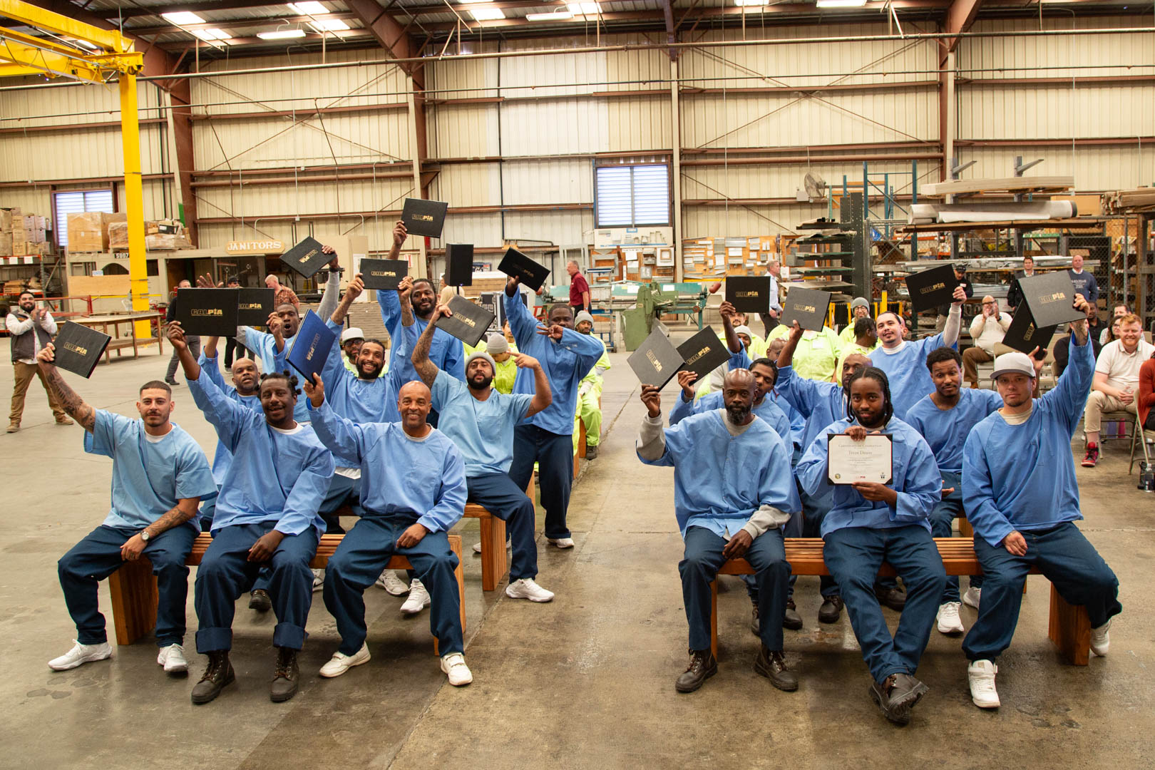 Graduates in construction trades job programs hold their certificates.