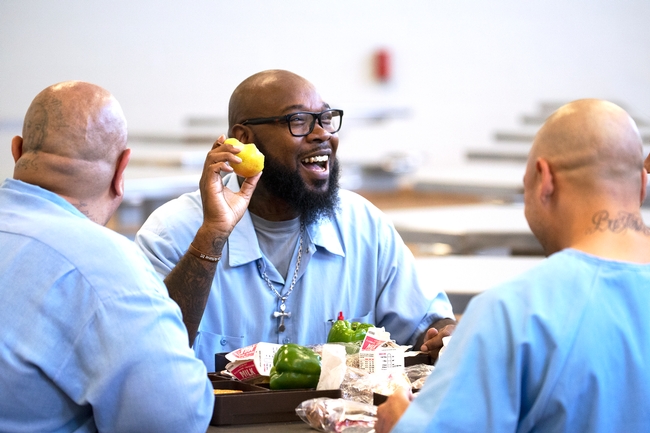 Incarcerated people enjoying fresh produce and fruit in a CDCR prison.