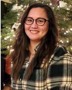 Marian Endriga in front of a Christmas tree.