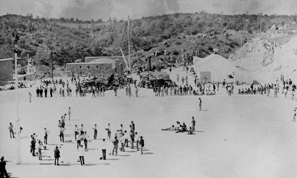 A band marches and practices in the field at Folsom State Prison in 1900.