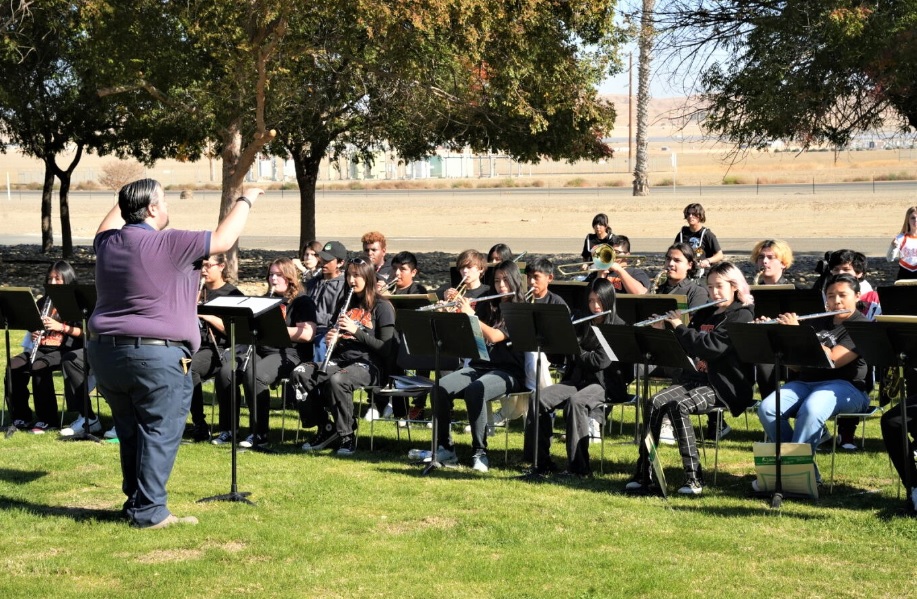 A high school band performing in front of a prison administration building.
