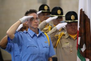 CCWF veterans support group color guard salutes while standing next to CDCR honor guard.