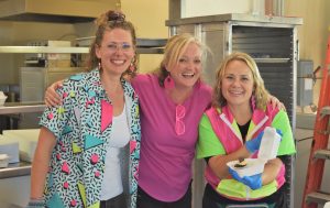 Three women wearing neon colors inside SCC.