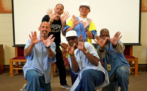 ASL graduation at San Quentin with people showing their excitement through hand gestures.