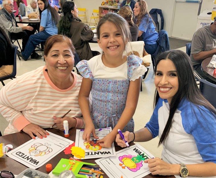 Families color a turkey wanted poster during a visiting event at CIW.