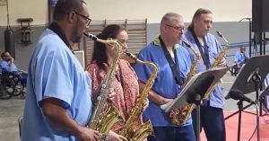 CMF distinguished school celebration with a band playing in the prison gymnasium.