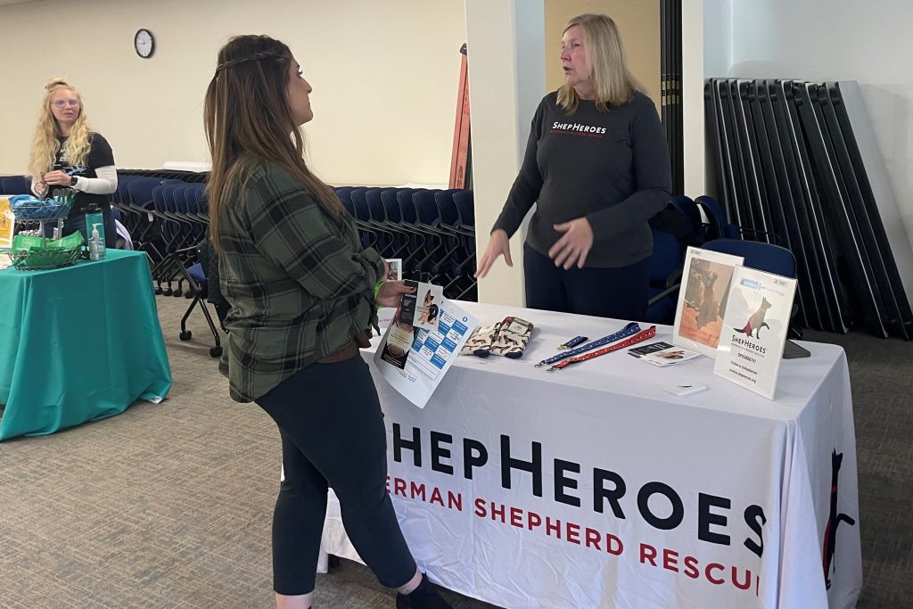 Two people discuss the mission of ShepHeroes, a dog rescue organization.