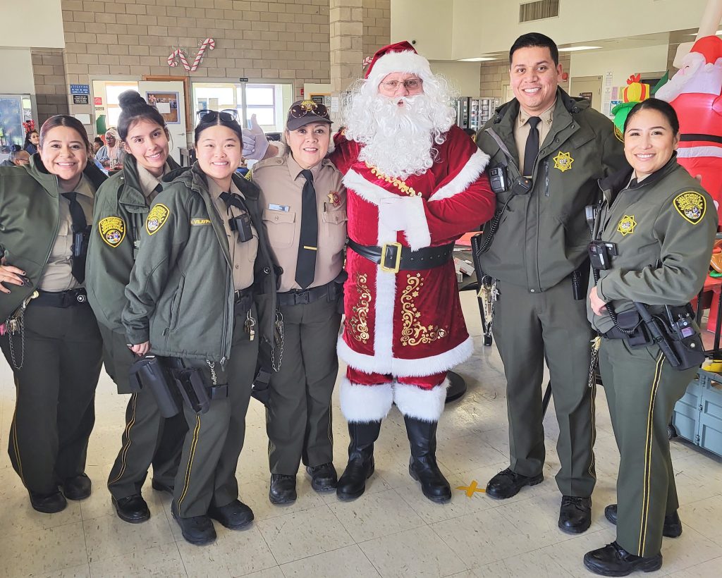 A group photo of prison staff and Santa Claus.