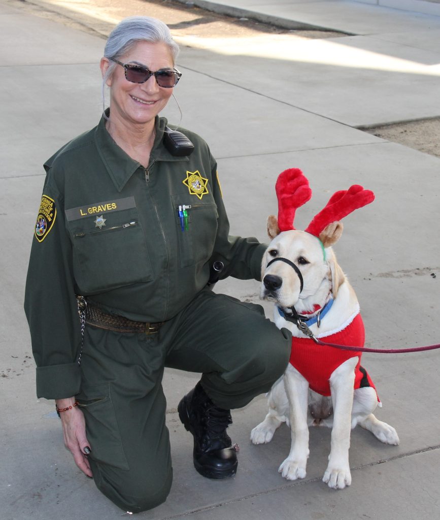 A correctional officer and one of the Canine Companion dogs.