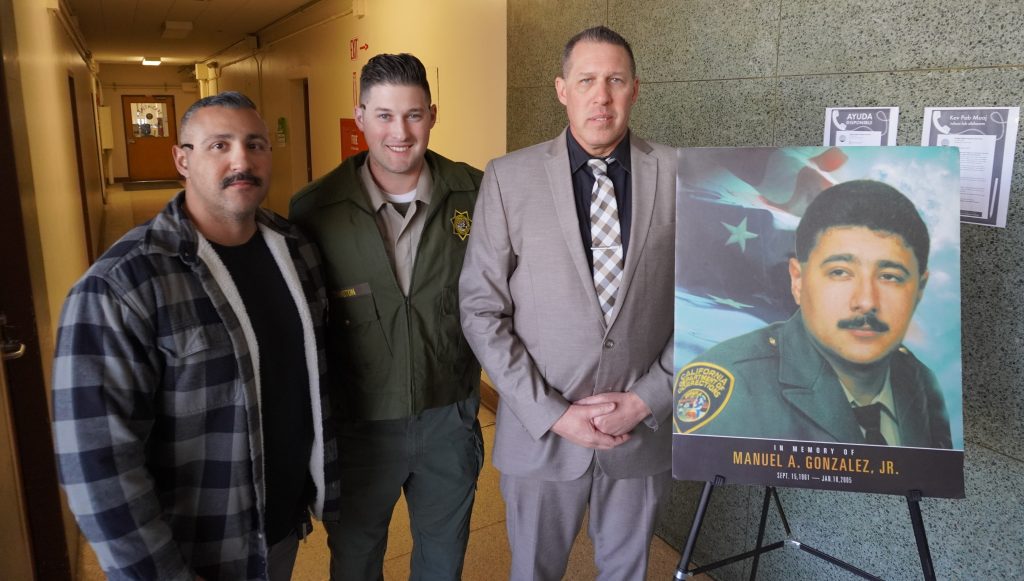 CIM staff standing with portrait of Manuel Gonzalez