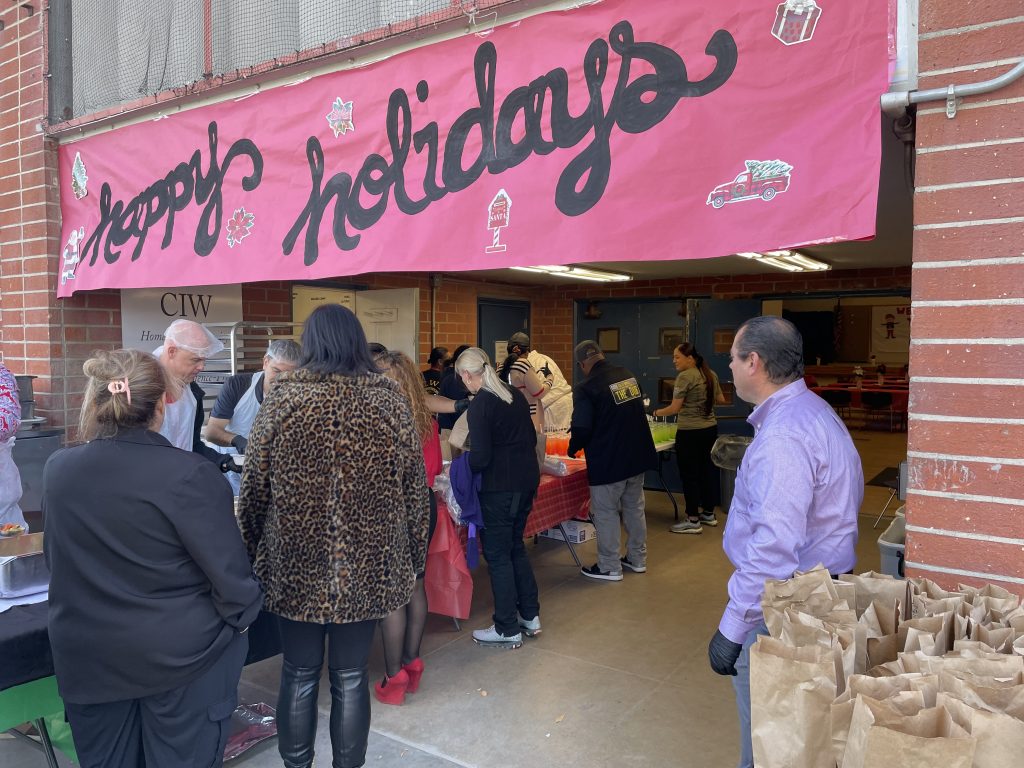 CDCR staff enter a building with banner that reads Happy Holidays.