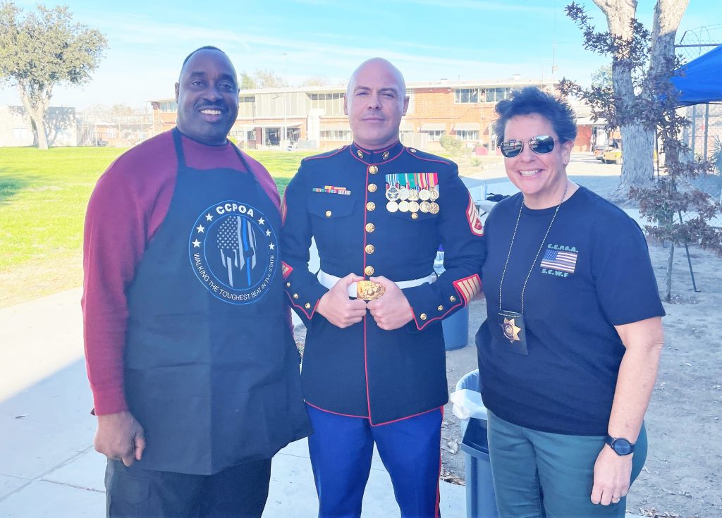 A US Marine stands between two staff members from California Institution for Women.