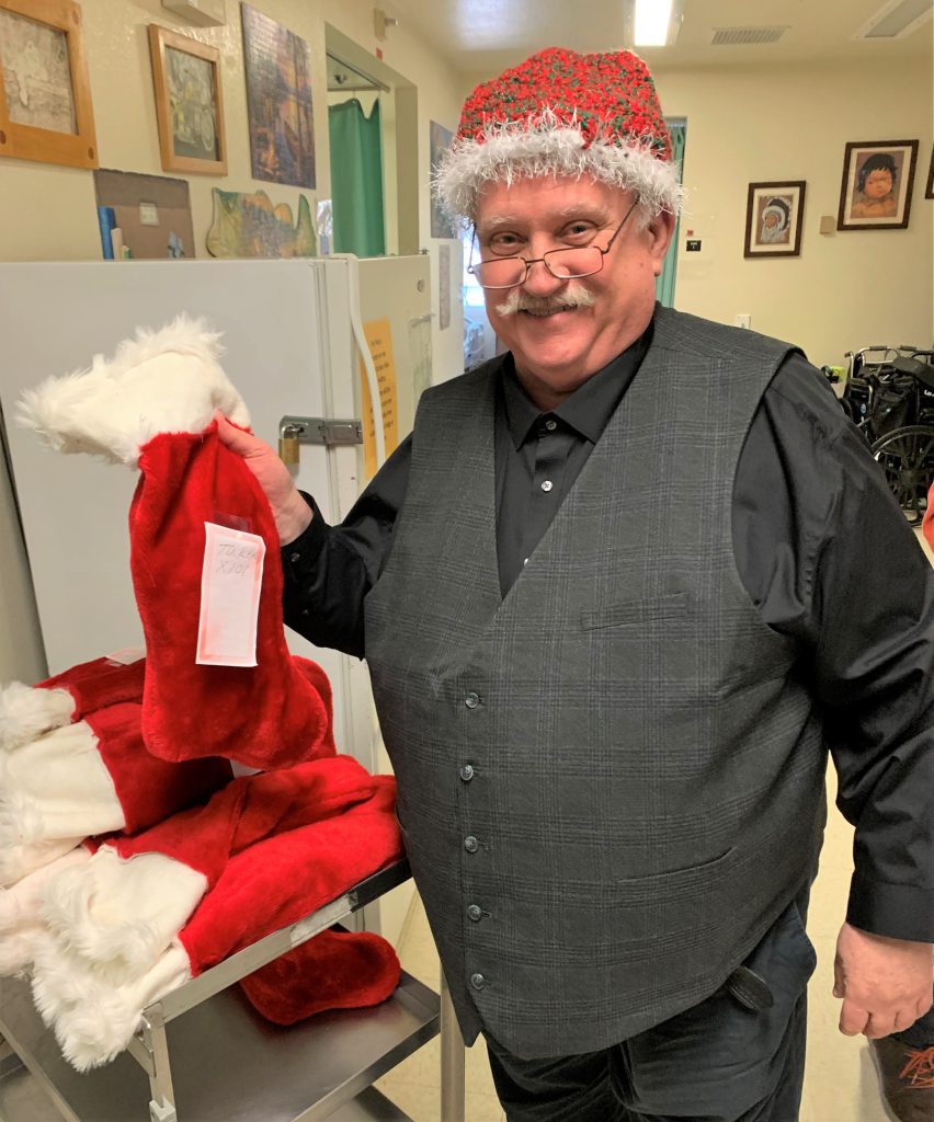 A staff chaplain prepares stockings to give to hospice patients for the holidays at California Medical Facility.