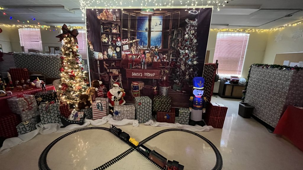 A Christmas display with a train track and the words Santa's Toyshop in the background.