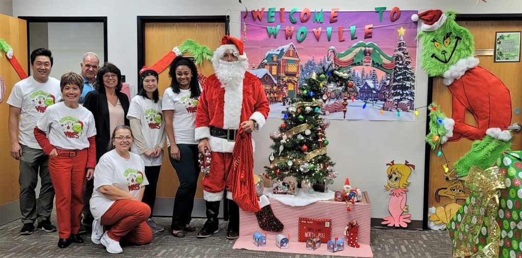 Staff with holiday decorations and Santa.