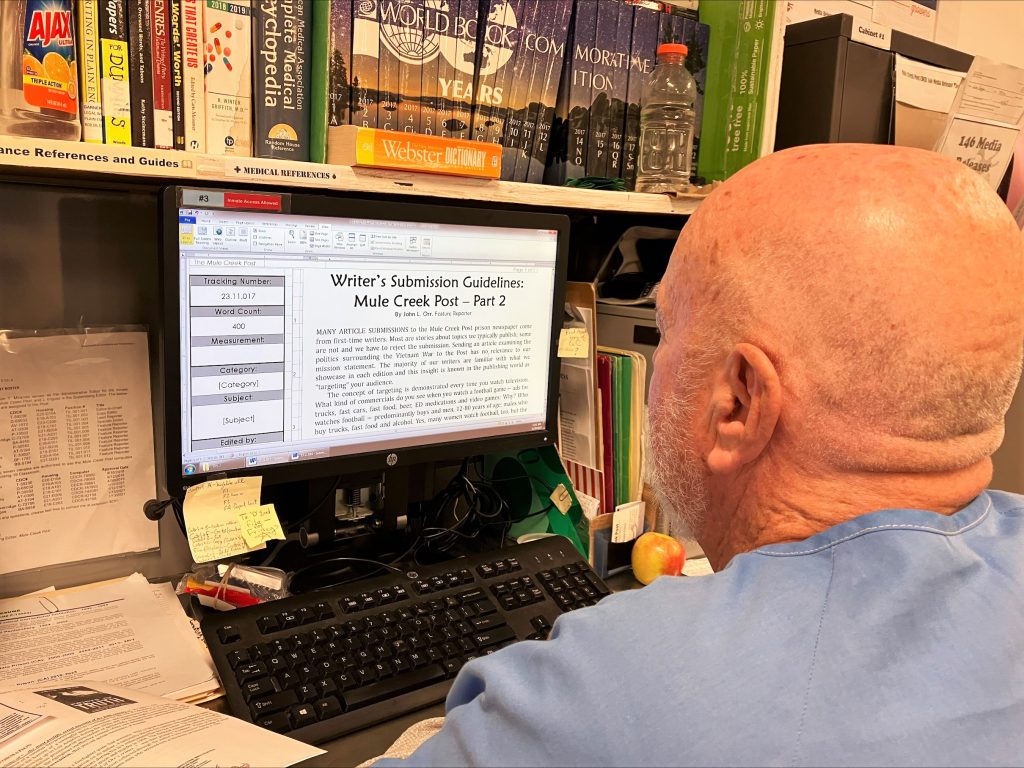 Mule Creek Post submission guidelines can be seen on a computer screen with an incarcerated person reading the description.