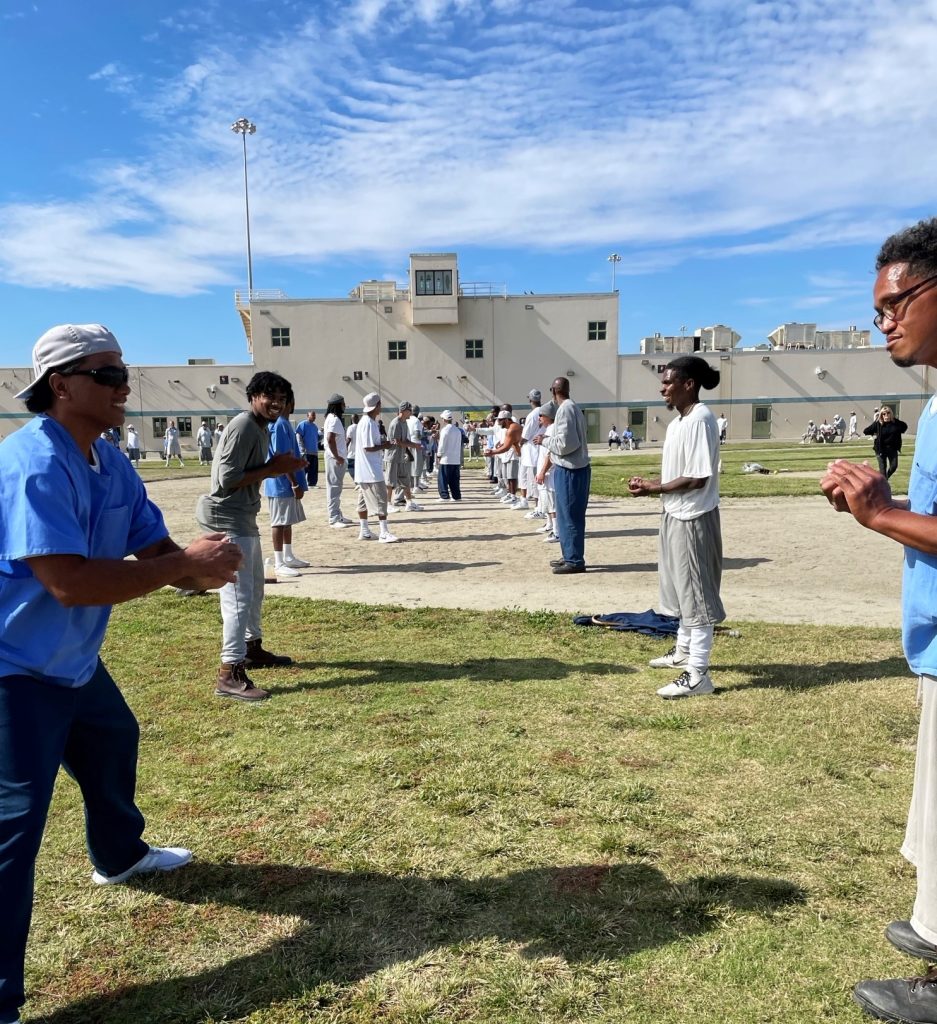 Incarcerated people line up opposite each other to take part in an egg toss.