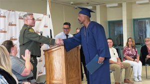 A warden shakes hands with an incarcerated graduate, one of many milestones at the Substance Abuse Treatment Facility in Corcoran.