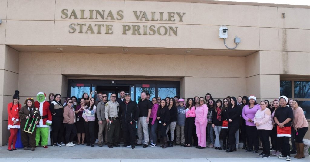 Staff stand in front of the prison administration building. 