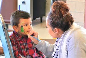 A young boy has his face painted at Valley State Prison during a special Christmas holiday visiting event.