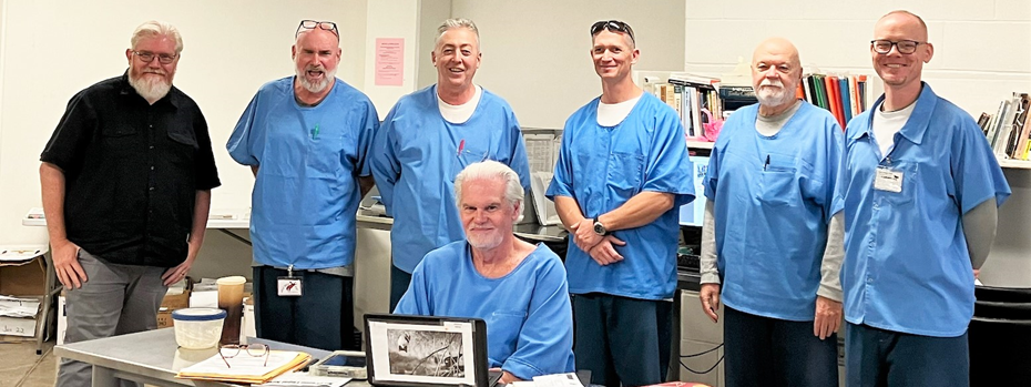 A group of incarcerated writers and editors at Mule Creek State Prison with a visitor from CDCR headquarters.