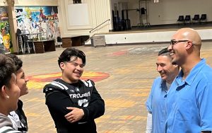Incarcerated fathers speak with high school football team players in the gym at the Correctional Training Facility in Soledad.