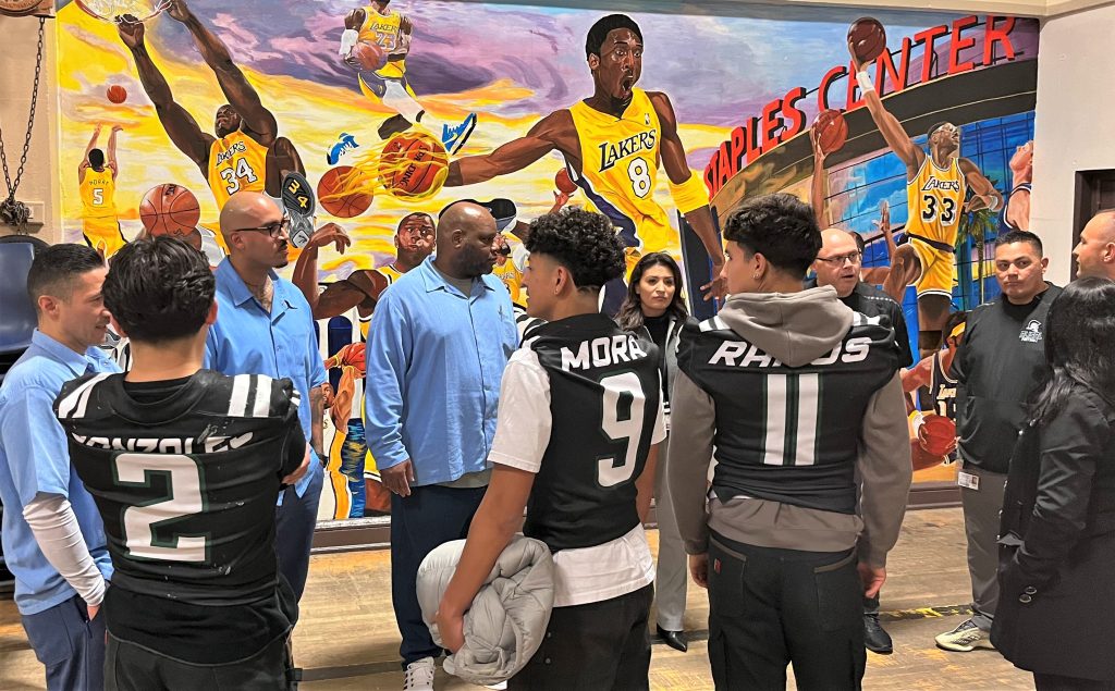 High school football players speak with incarcerated people.